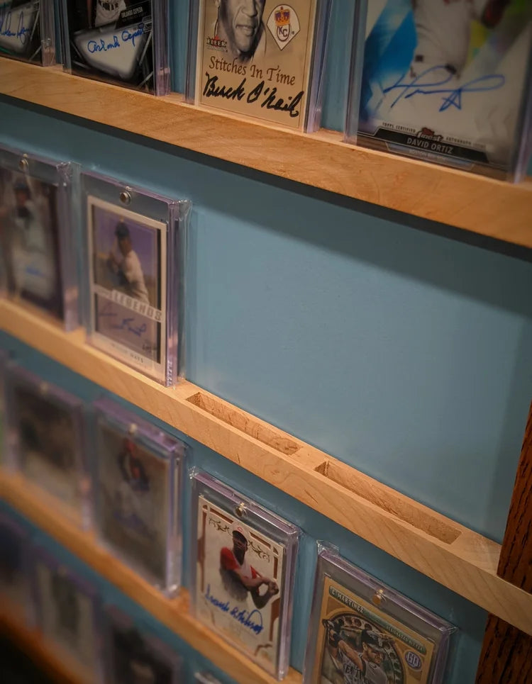 Collection of sports trading cards displayed on a blue card holder with wooden border.