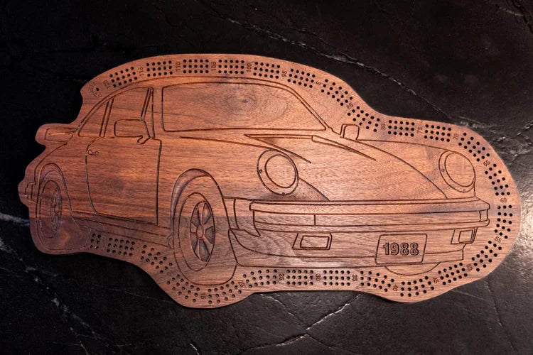 Wooden car-shaped cribbage board with '1988' on a dark surface
