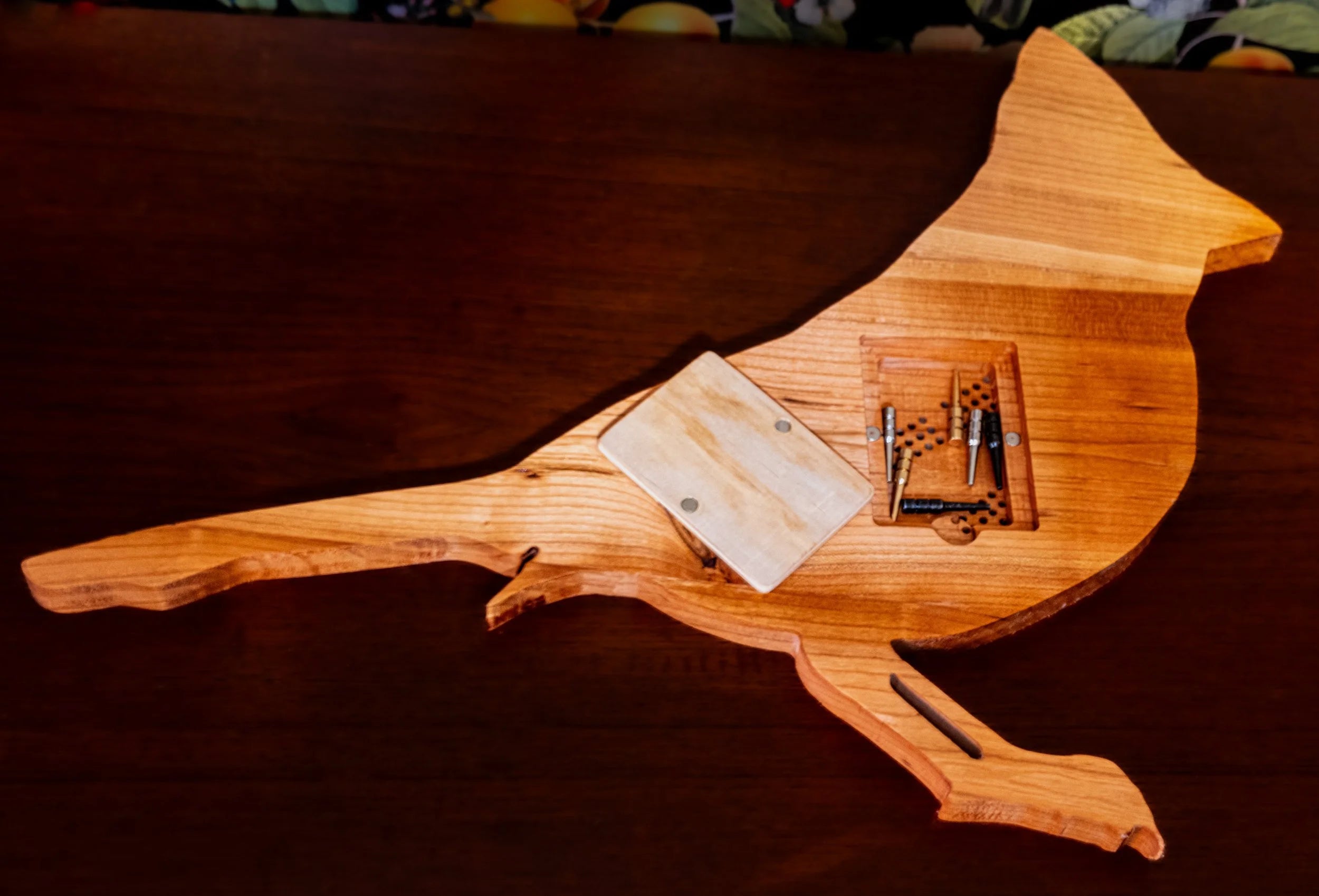 Wooden bird-shaped cribbage board on a dark surface