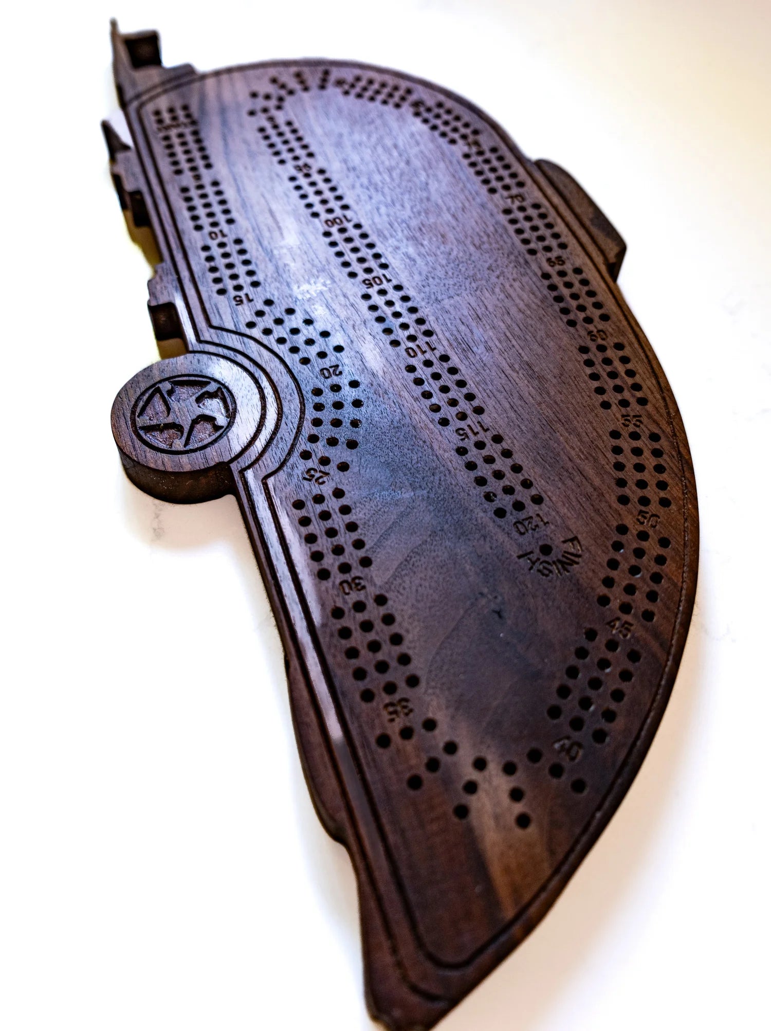 Wooden cribbage board with pegs on a white background