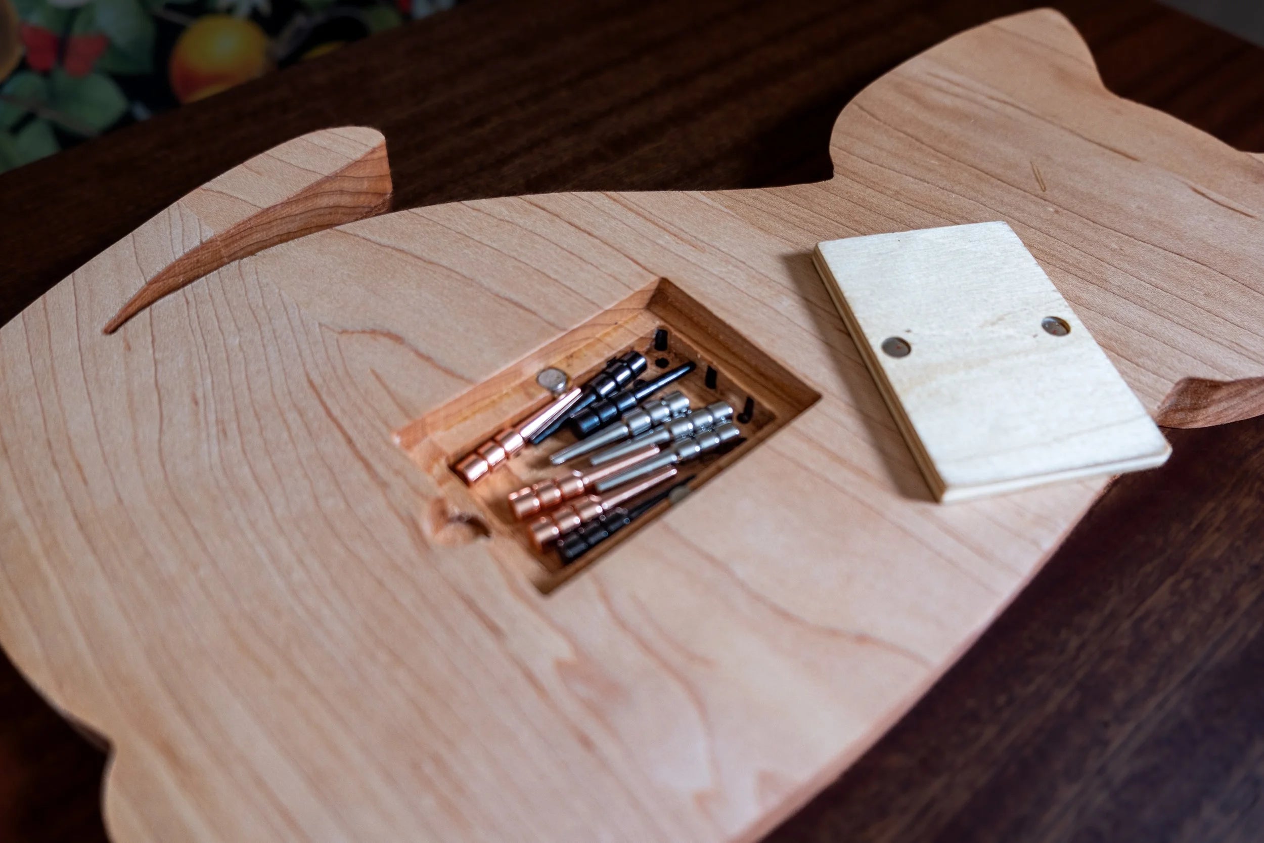 Wooden cat-shaped cribbage board on a dark background