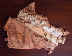 Wooden Canada-shaped cribbage board on a wooden surface