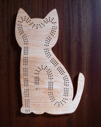 Wooden cat-shaped cribbage board on a dark background