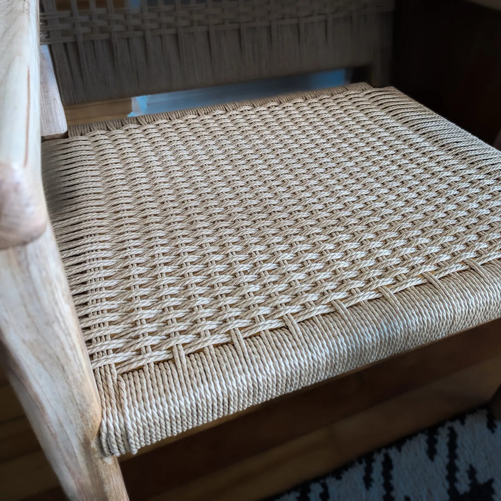 Close-up of a woven chair seat with a wooden frame.
