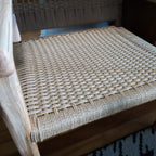 Close-up of a woven chair seat with a wooden frame.
