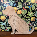 Wooden dog-shaped cribbage board on a floral-patterned background