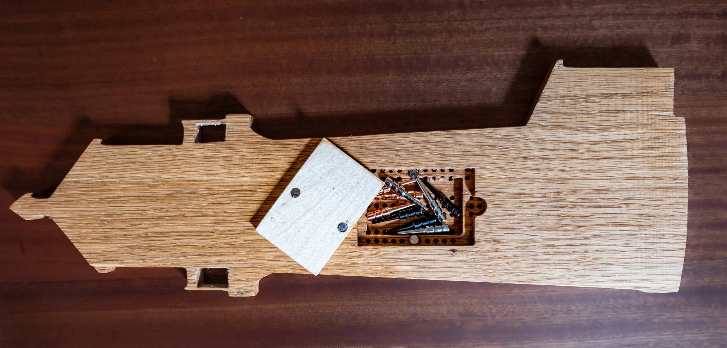 Wooden lighthouse-shaped cribbage board on a wooden surface