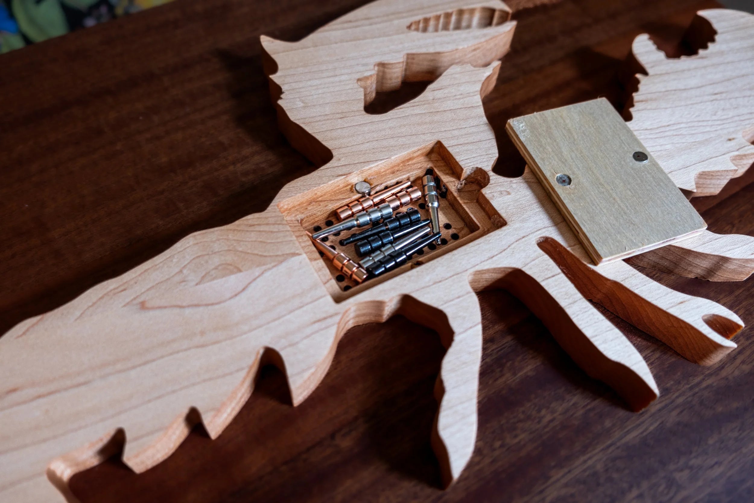 Wooden lobster-shaped cribbage board on a wooden surface