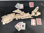Wooden cribbage board with playing cards on a dark surface