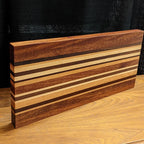 Wooden cutting board with striped pattern on a wooden surface