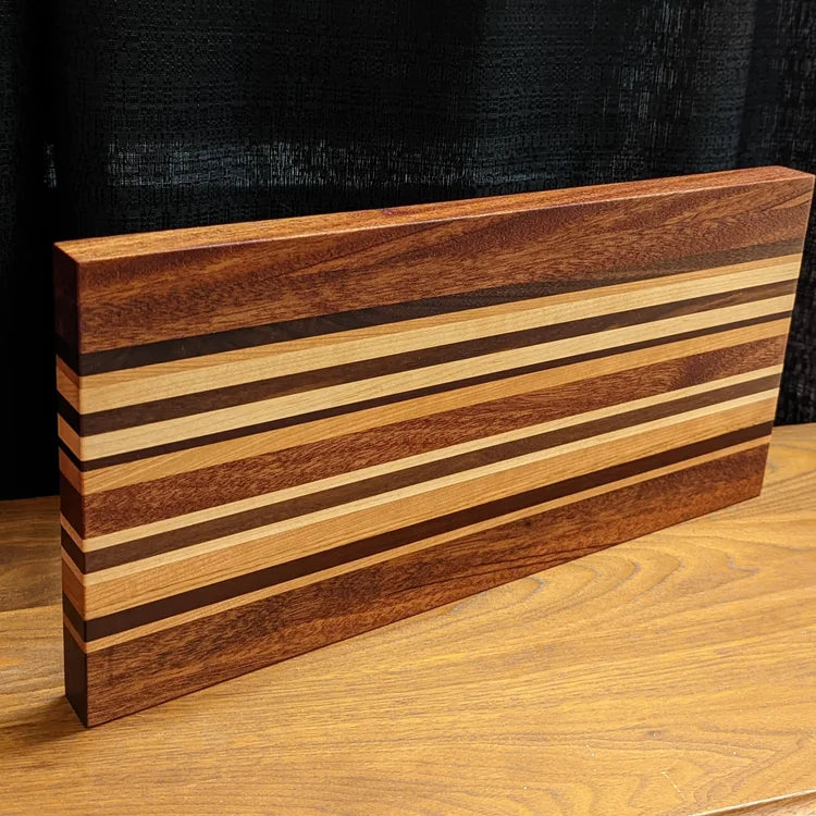 Wooden cutting board with striped pattern on a wooden surface