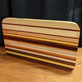 Wooden cutting board with striped pattern on a wooden surface