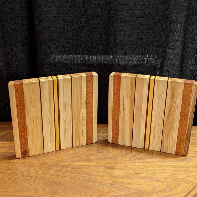 Two wooden cutting boards with a striped pattern on a wooden surface.