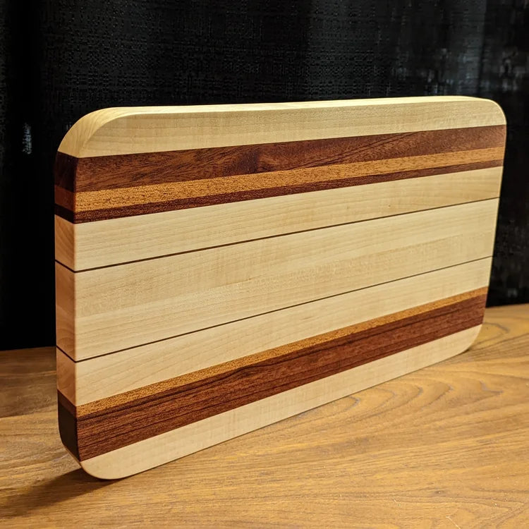 Wooden cutting board with striped pattern on a wooden surface