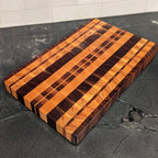 Wooden cutting board with striped pattern on a dark surface
