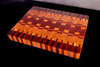 Wooden cutting board with a geometric pattern on a black surface.