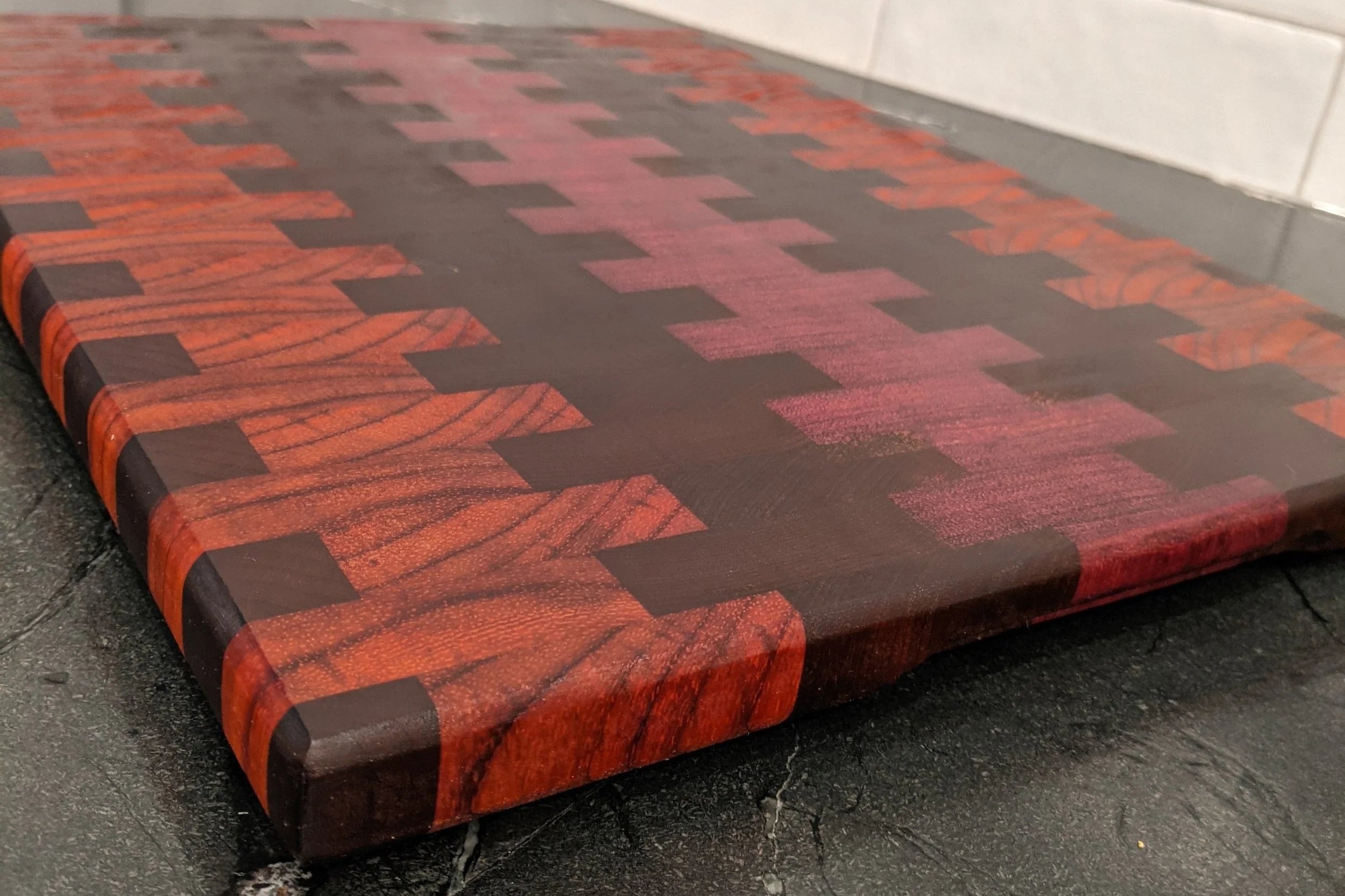 Red and black patterned cutting board on a dark surface