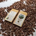 Two packages of rhubarb seeds on a bed of dried rhubarb leaves.