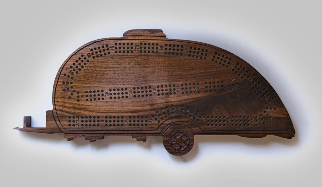 Wooden cribbage board shaped like a camper on a white background