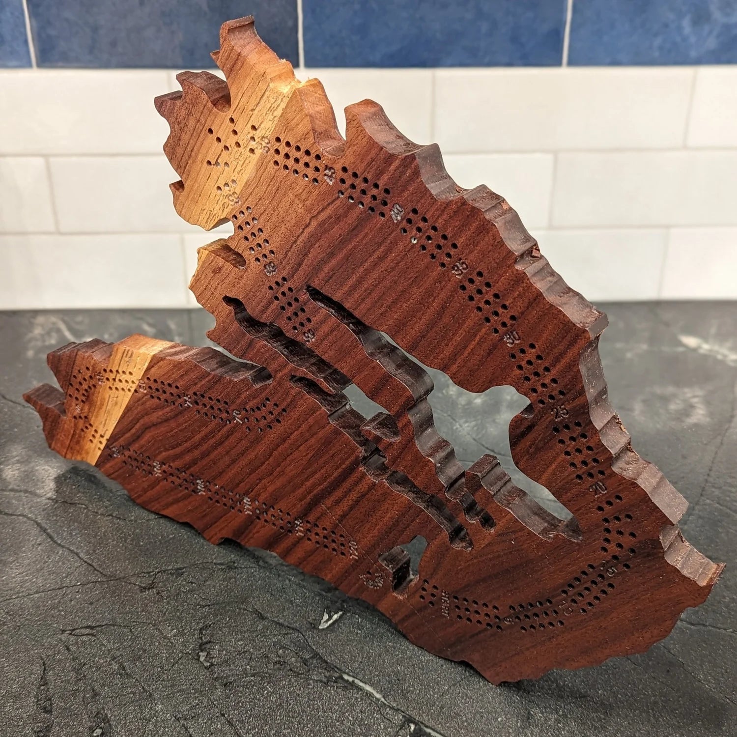 Wooden cribbage board in the shape of Cape Breton, Nova Scotia.