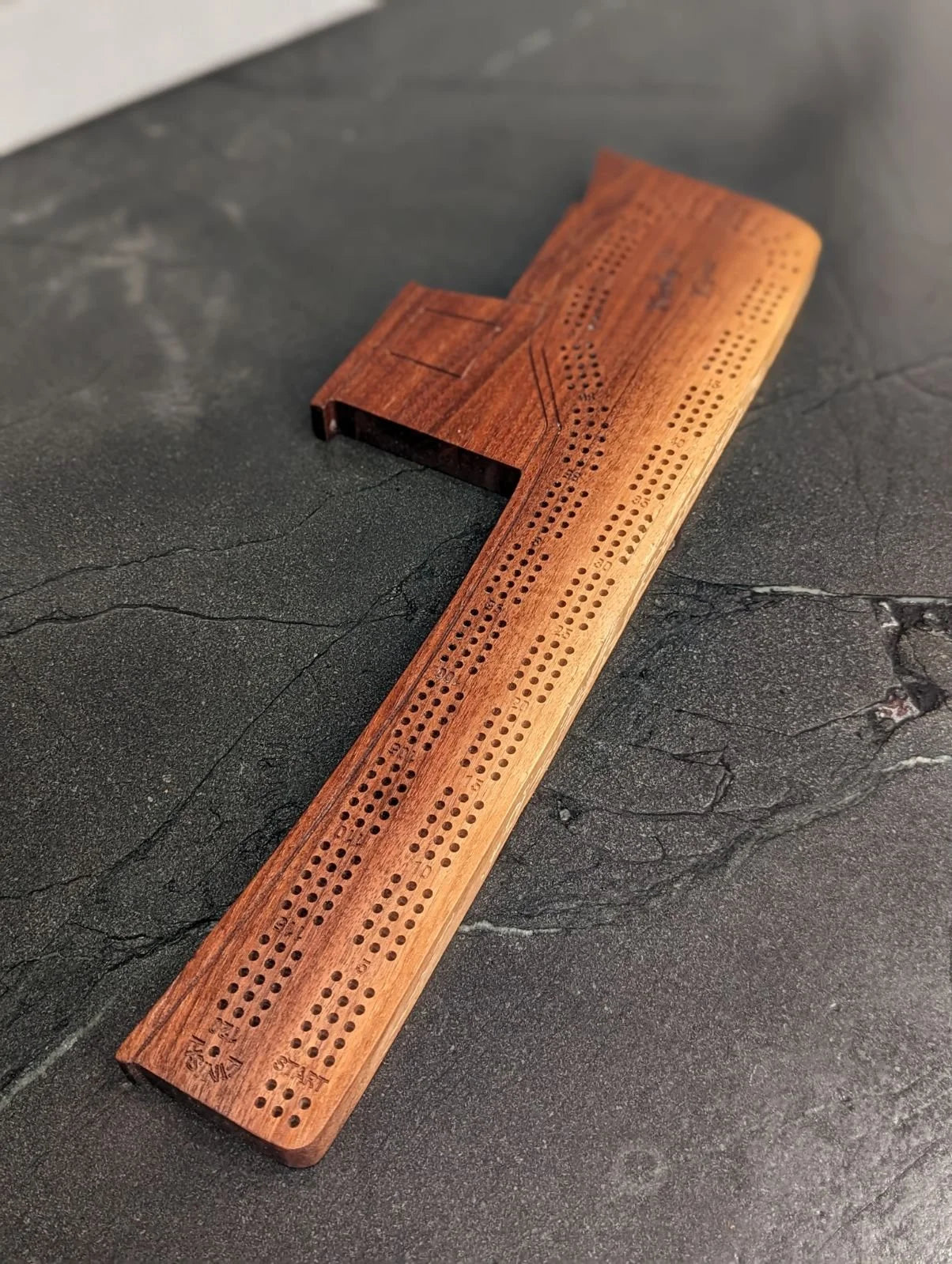 Wooden cribbage board on a dark surface