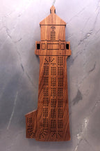 Wooden lighthouse cribbage board on a gray surface